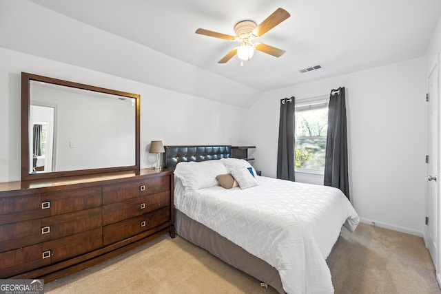 bedroom with visible vents, baseboards, light colored carpet, vaulted ceiling, and a ceiling fan