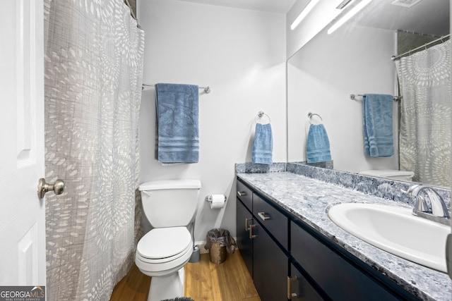 bathroom featuring vanity, a shower with curtain, wood finished floors, visible vents, and toilet