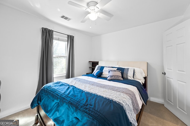 carpeted bedroom with visible vents, baseboards, and a ceiling fan