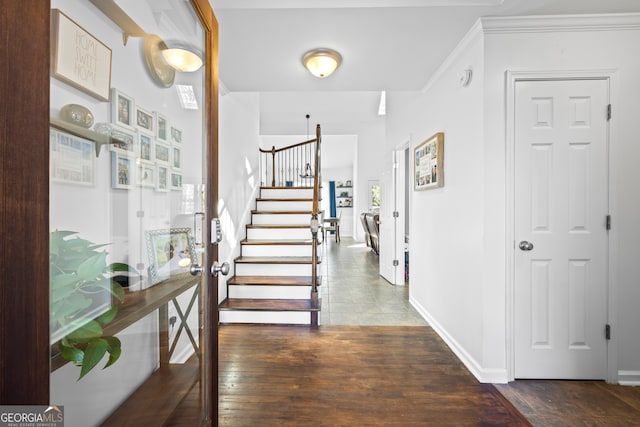 entrance foyer featuring stairs, wood finished floors, baseboards, and ornamental molding