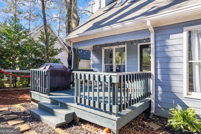 wooden deck with covered porch and area for grilling