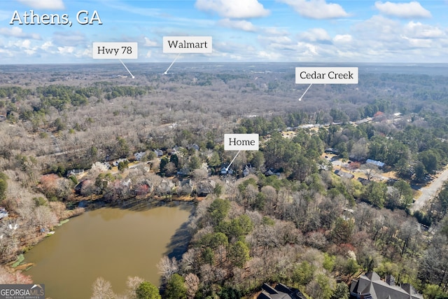 aerial view featuring a forest view and a water view