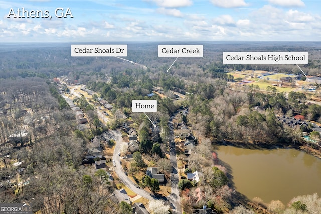 drone / aerial view featuring a wooded view and a water view