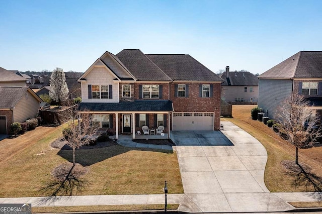 view of front of house with brick siding, a front lawn, a porch, a garage, and driveway