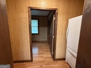 hall featuring wood walls and light wood-style flooring