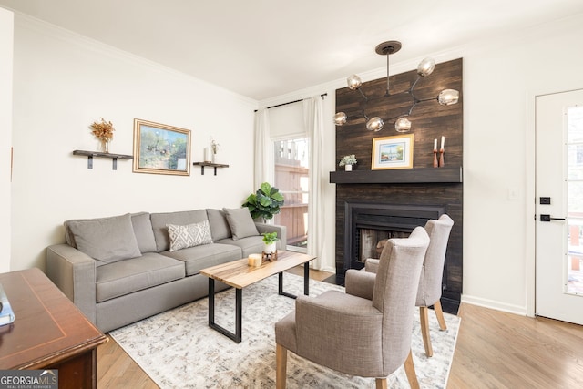 living room featuring a fireplace, wood finished floors, and crown molding