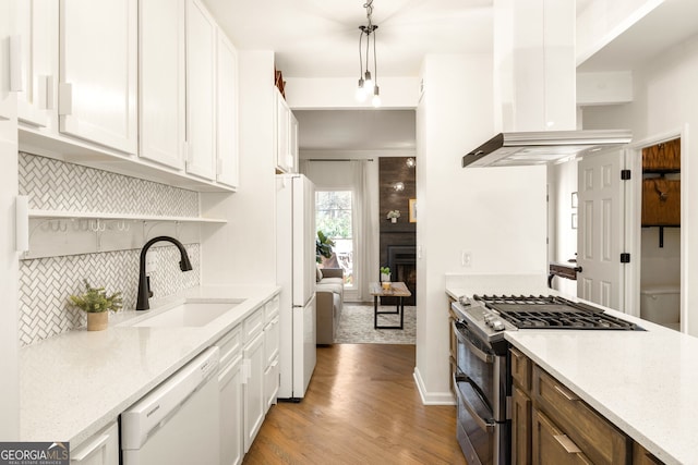 kitchen featuring ventilation hood, light wood-type flooring, white appliances, white cabinetry, and a sink