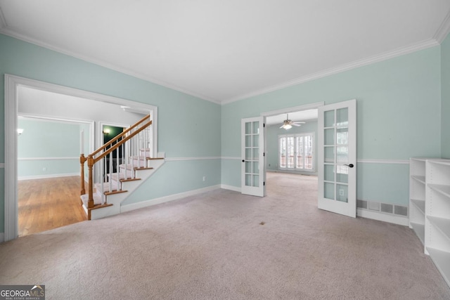 spare room featuring visible vents, carpet floors, ornamental molding, stairs, and french doors