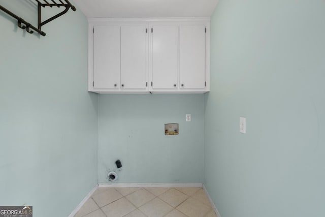 washroom featuring light tile patterned floors, baseboards, hookup for an electric dryer, cabinet space, and washer hookup