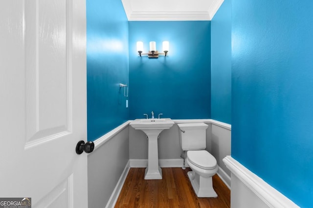 bathroom featuring wood finished floors, toilet, baseboards, and ornamental molding