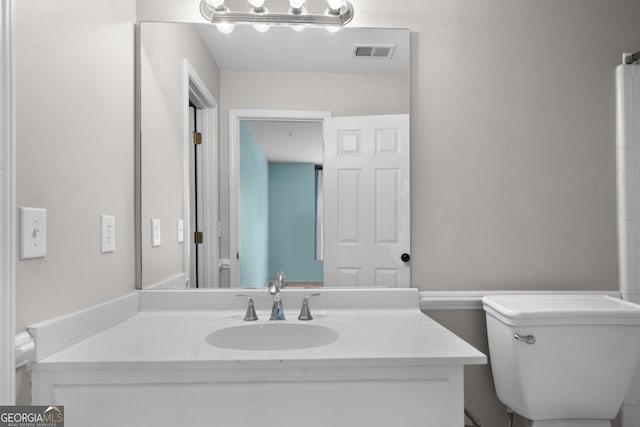 bathroom featuring visible vents, toilet, and vanity