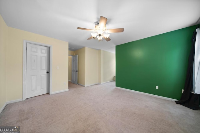 spare room featuring baseboards, carpet floors, and ceiling fan