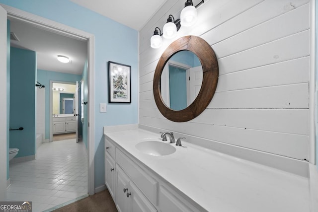 bathroom with toilet, vanity, bathing tub / shower combination, and baseboards