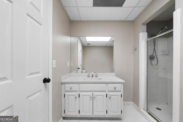 bathroom with vanity, a shower stall, and a drop ceiling