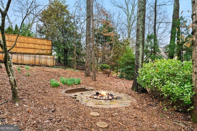 view of yard featuring a fire pit and fence