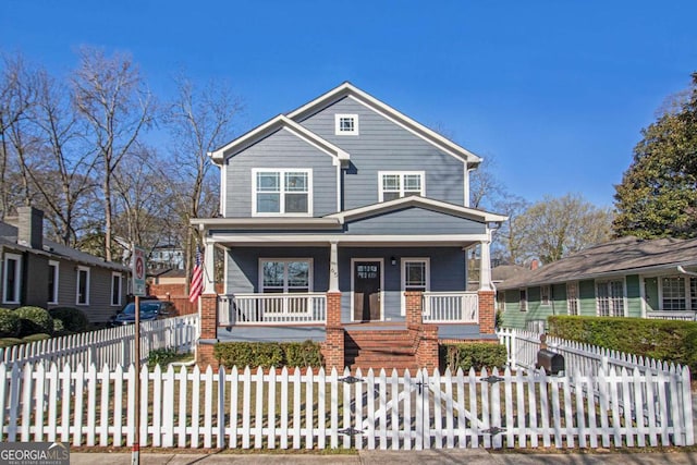 view of front of property with a fenced front yard, brick siding, and a porch