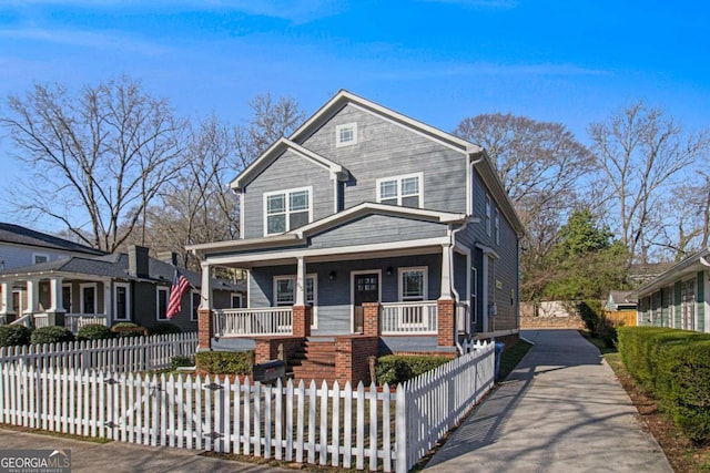 view of front of house with a fenced front yard, brick siding, and a porch