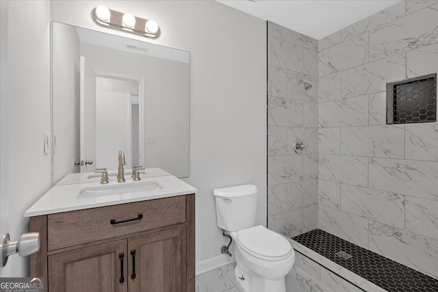 full bath featuring vanity, toilet, marble finish floor, and a tile shower