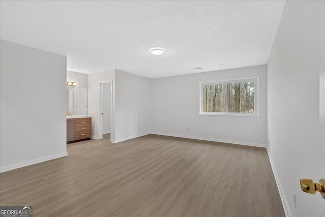 unfurnished bedroom featuring baseboards and wood finished floors