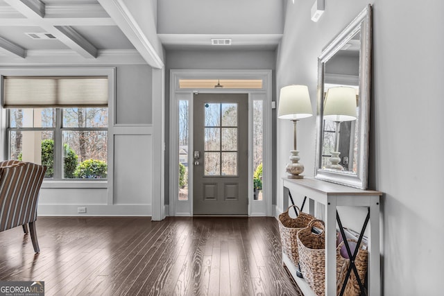 entrance foyer featuring beam ceiling, a healthy amount of sunlight, coffered ceiling, and dark wood-type flooring