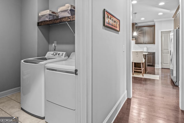 laundry area with baseboards, recessed lighting, ornamental molding, washer and dryer, and light wood-type flooring