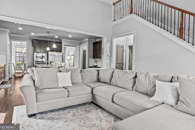 living room featuring dark wood finished floors, recessed lighting, and crown molding