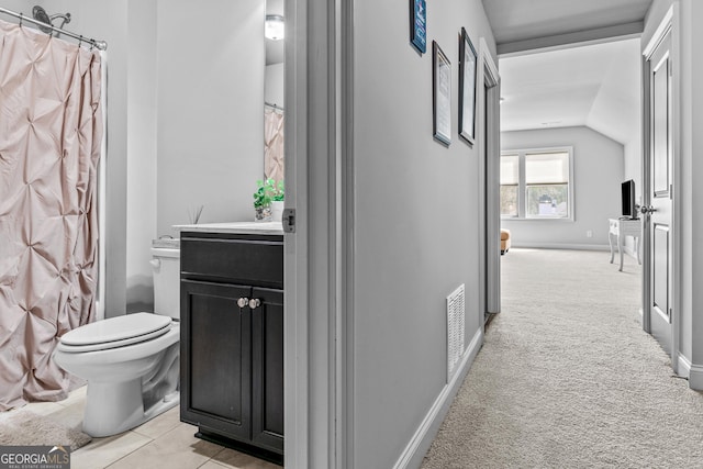 corridor with visible vents, light carpet, baseboards, and vaulted ceiling