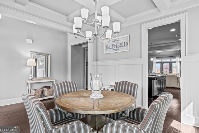 dining space featuring wood finished floors, beam ceiling, crown molding, a decorative wall, and a chandelier