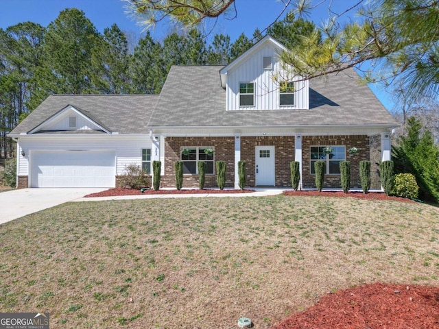 view of front facade with a front yard, a porch, brick siding, and an attached garage