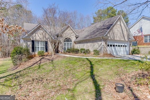 view of front of house featuring brick siding, an attached garage, concrete driveway, and a front yard