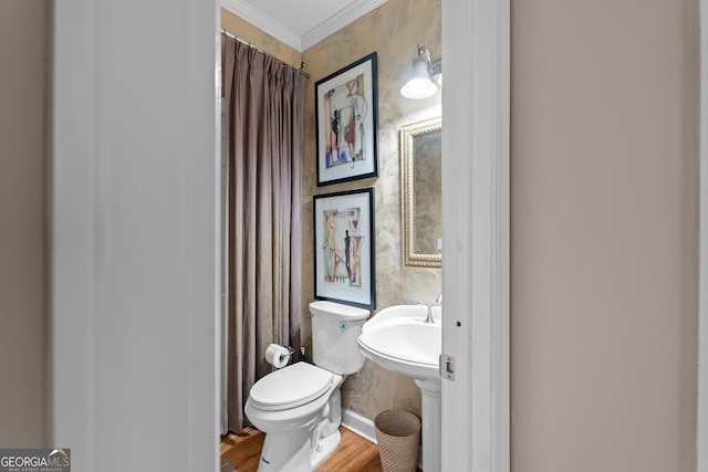 bathroom with wood finished floors, toilet, and ornamental molding