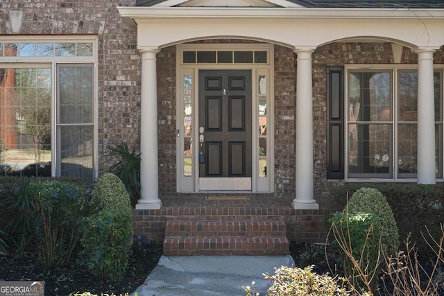 entrance to property featuring brick siding