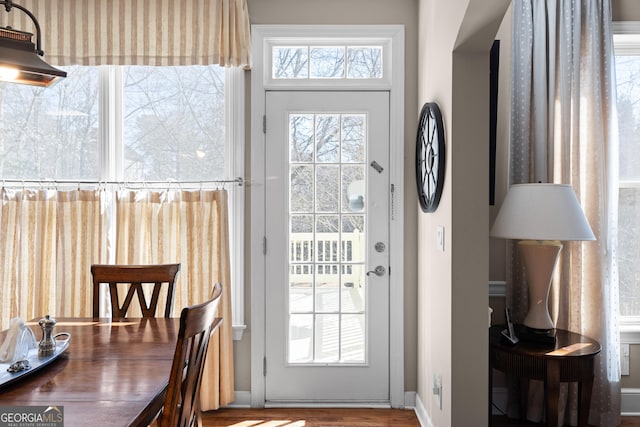 doorway to outside with wood finished floors and baseboards