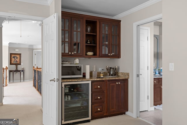 bar with stainless steel microwave, crown molding, beverage cooler, and baseboards