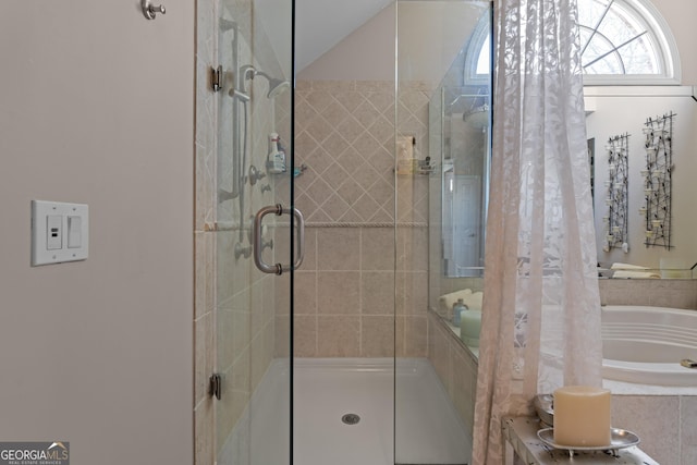 full bathroom featuring a shower stall and a relaxing tiled tub