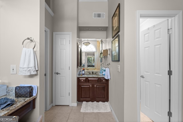 bathroom featuring vanity, baseboards, visible vents, and tile patterned flooring