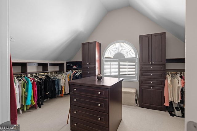 spacious closet with lofted ceiling and light carpet