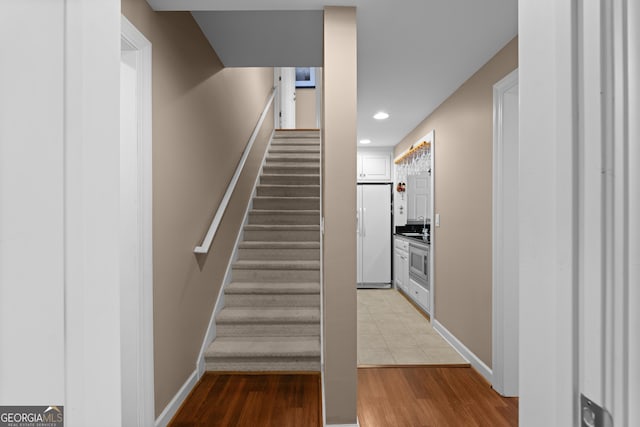 stairs featuring recessed lighting, baseboards, and wood finished floors