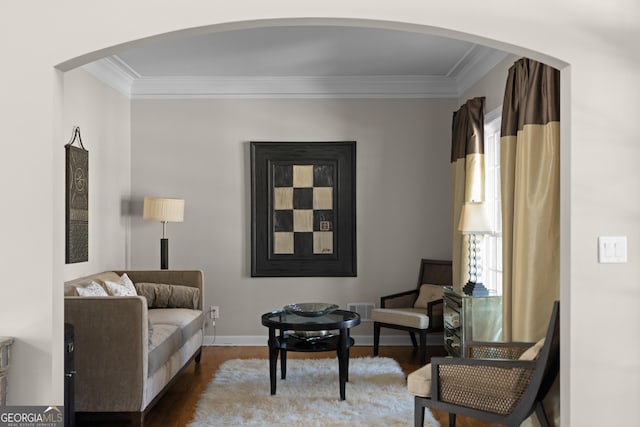 sitting room featuring baseboards, wood finished floors, visible vents, and ornamental molding