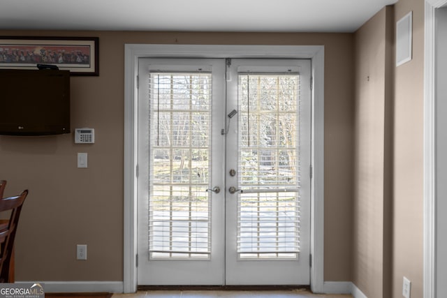 doorway to outside featuring french doors and baseboards