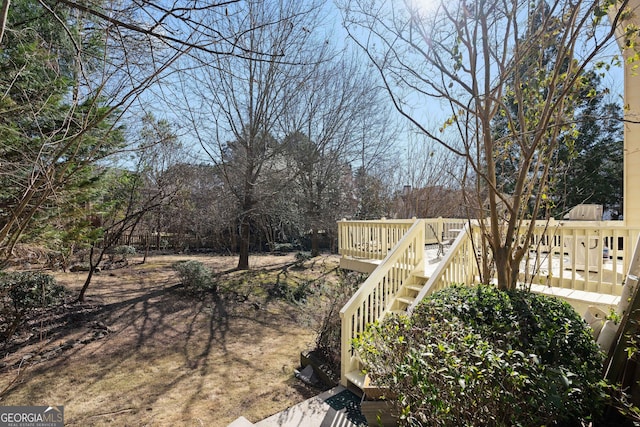 view of yard with a wooden deck and stairs