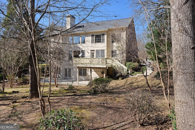 rear view of house featuring a patio area, stairway, french doors, and a chimney