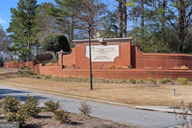 community / neighborhood sign featuring fence