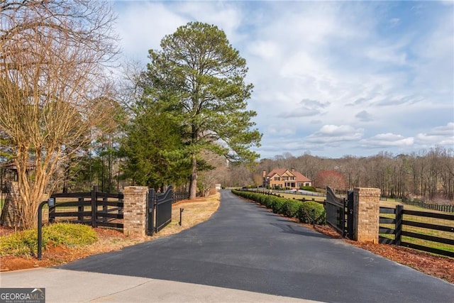 view of road with aphalt driveway and a gate