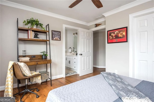 bedroom with ensuite bathroom, crown molding, baseboards, and wood finished floors