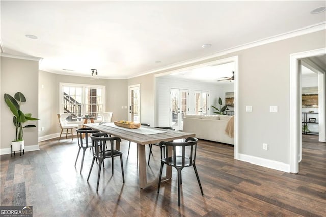 dining room featuring dark wood-style floors, baseboards, and ornamental molding