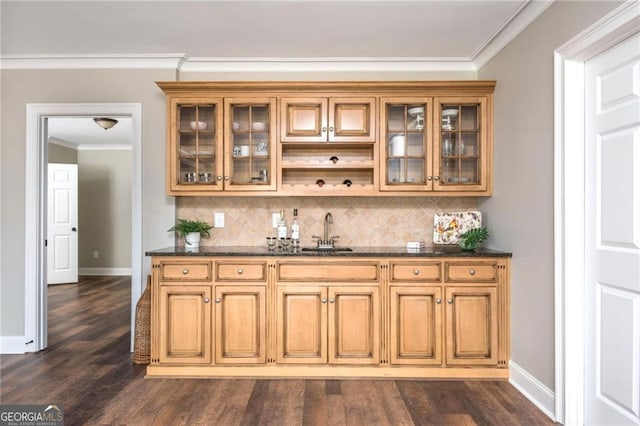 bar featuring backsplash, crown molding, dark wood-type flooring, and a sink