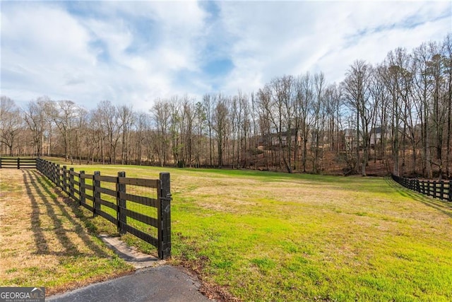 view of yard with a rural view and fence