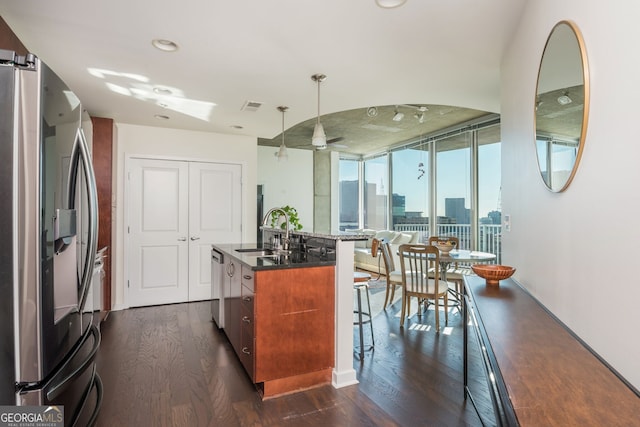 860 Peachtree St Unit 1418, Atlanta, GA 30308 - kitchen featuring appliances with stainless steel finishes, a wall of windows, a sink, a kitchen breakfast bar, and dark wood-type flooring