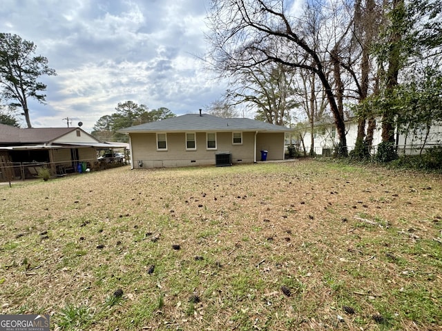 back of house featuring crawl space, central air condition unit, a yard, and fence